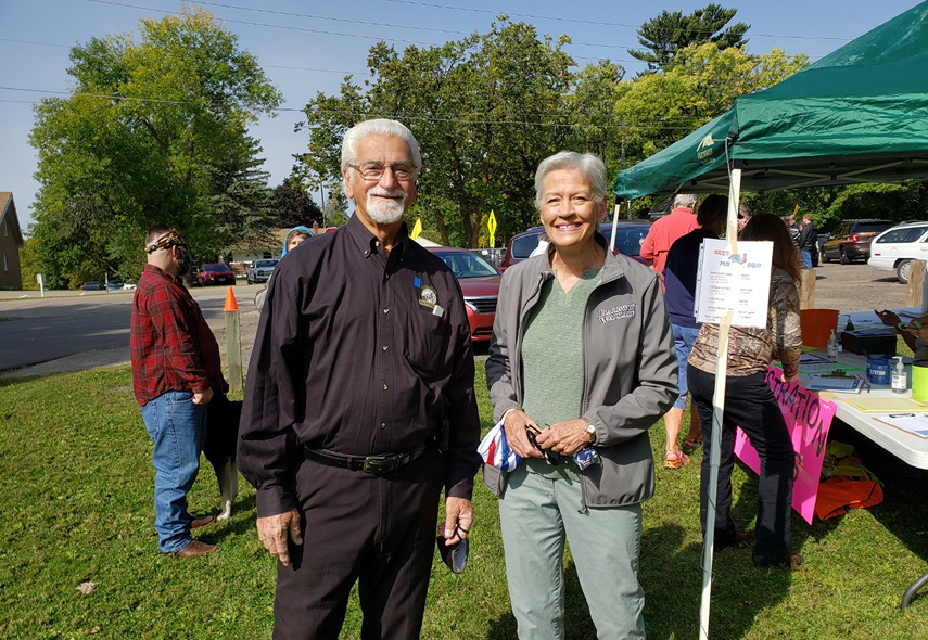 Shannon Bruce at community event with a green canopy and tables behind her.